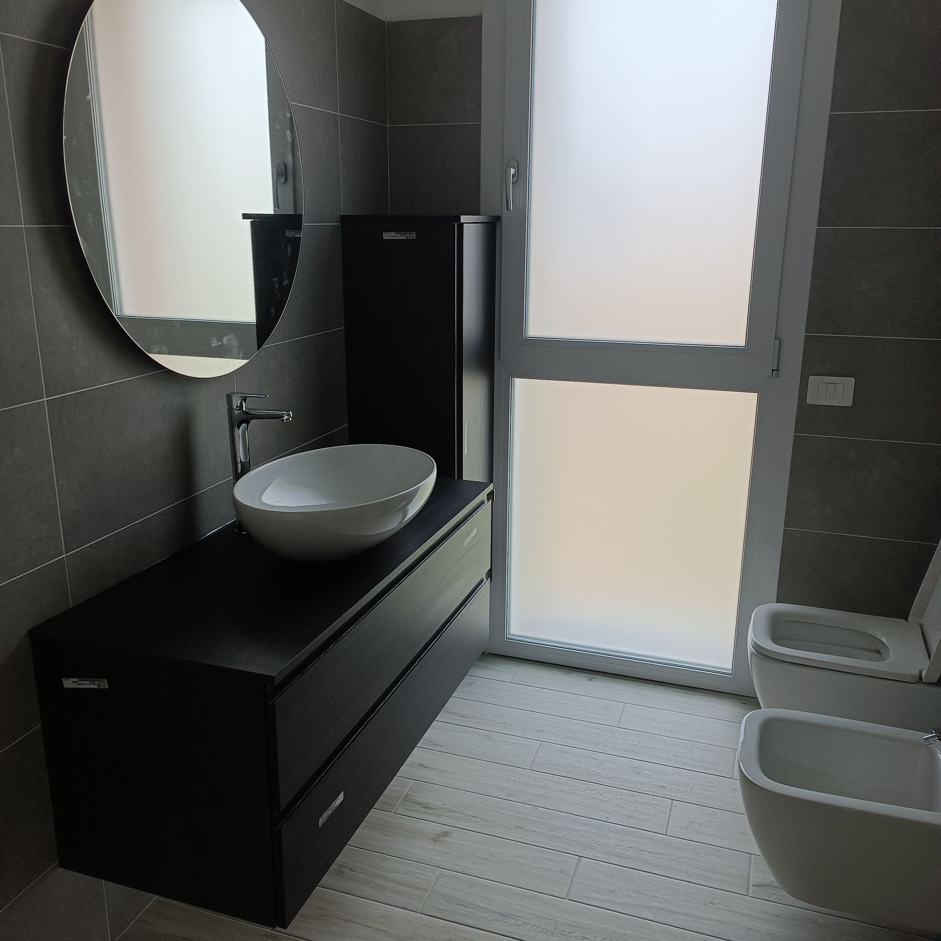 Un bagno con due water, un lavandino e uno specchio