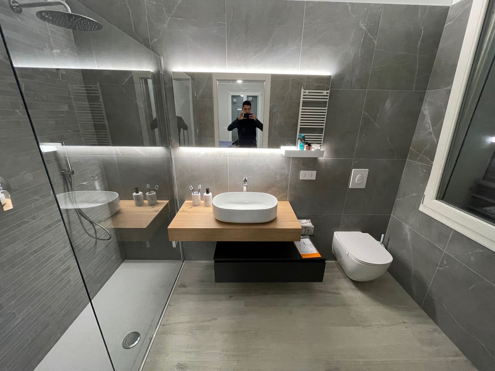 Un bagno con lavandino, WC, doccia e specchio.