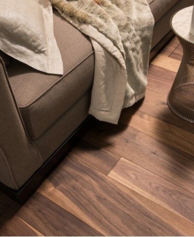 Un divano con una coperta sopra è appoggiato accanto a un pavimento in legno