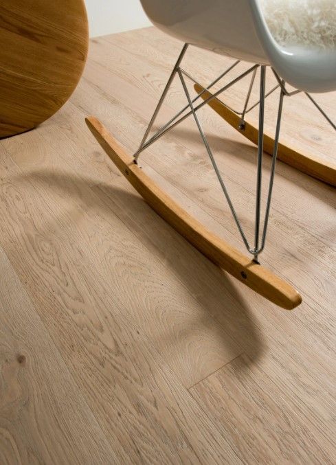 Una sedia a dondolo è appoggiata su un pavimento di legno