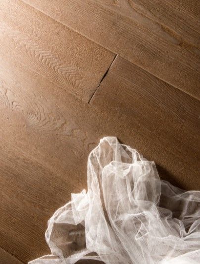 Un panno bianco è steso su un pavimento di legno.