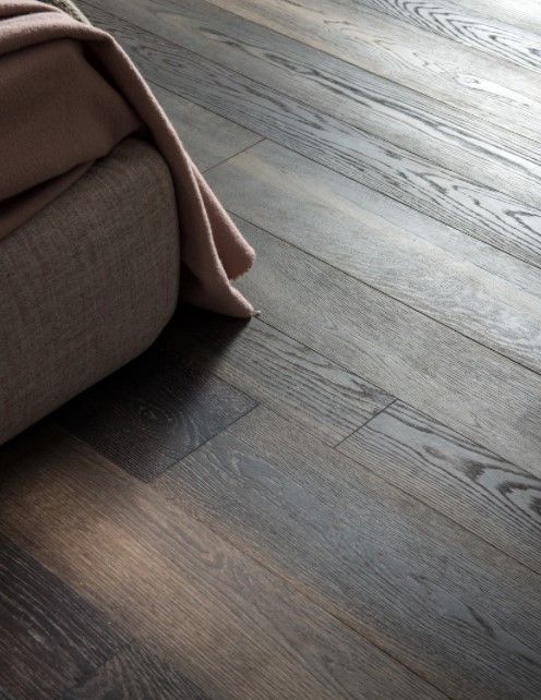 Un pavimento in legno con un letto sullo sfondo