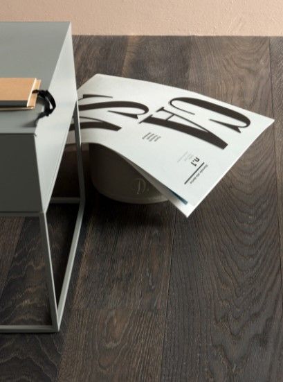 Una rivista è appoggiata sul pavimento accanto a un tavolo