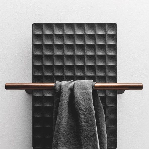 Un asciugamano è appeso a un portasciugamani di legno su una parete.