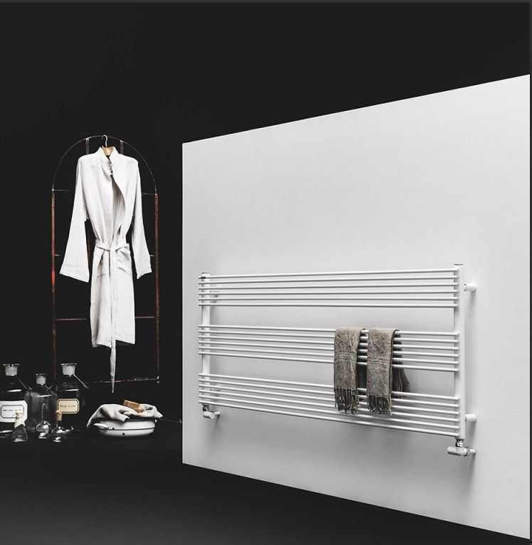 Un accappatoio è appeso su un attaccapanni accanto a un portasciugamani bianco