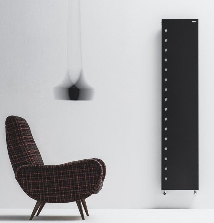 Una sedia è appoggiata davanti a un muro bianco accanto a un radiatore nero