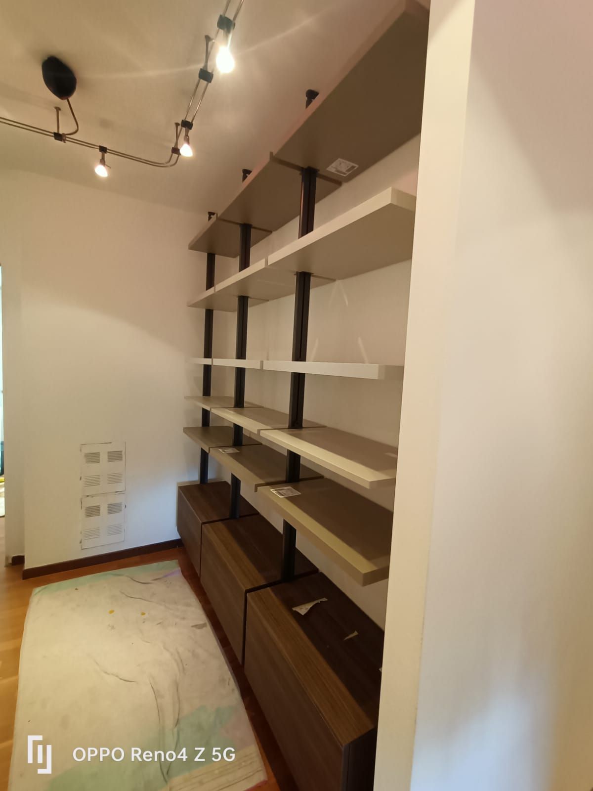 Una stanza con scaffali e un telefono con la scritta Oppo Reno4 Z 5G