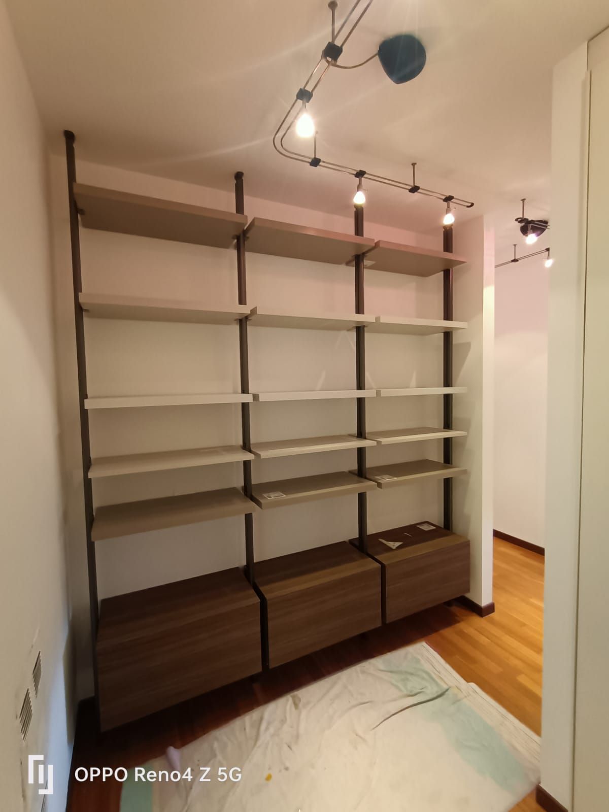 Una stanza con molti scaffali e luci sul soffitto.