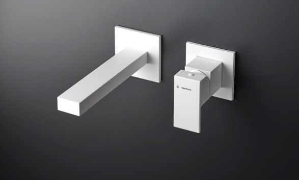 Un rubinetto bianco montato a parete su uno sfondo nero