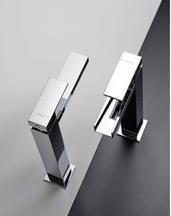 Due rubinetti cromati sono appoggiati su una superficie bianca e nera.