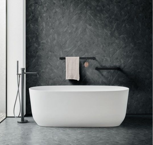 Una vasca da bagno bianca in un bagno con una parete nera