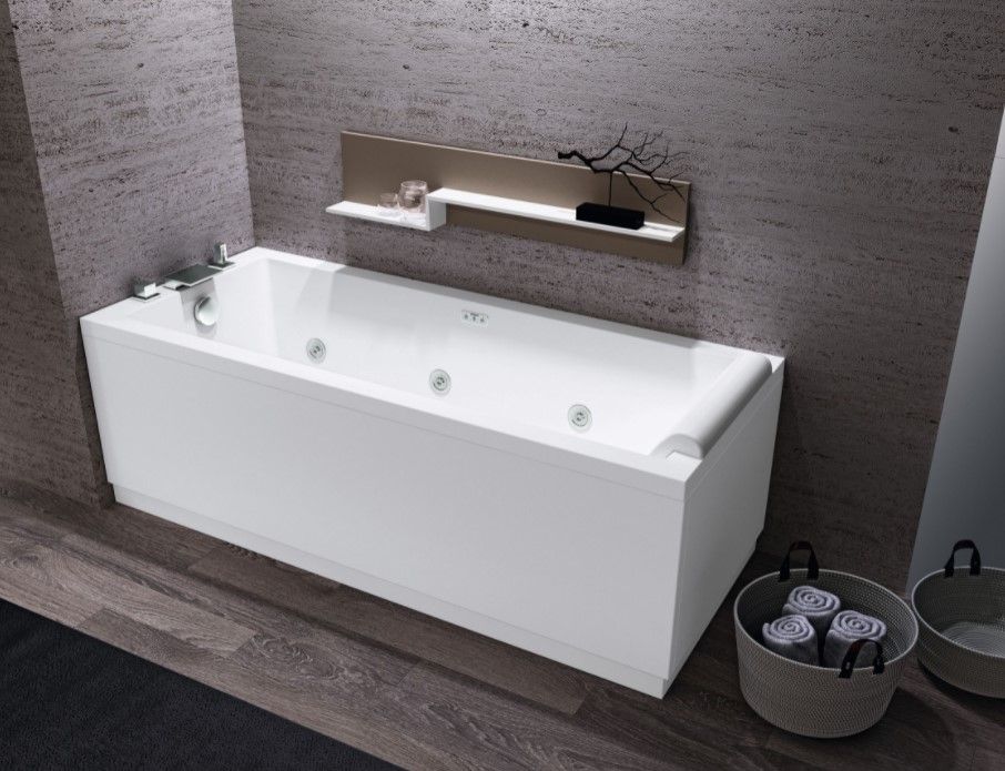 Una vasca da bagno in un bagno con una mensola sopra