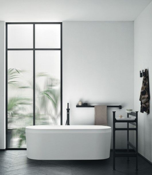 Un bagno con una grande finestra e una vasca da bagno