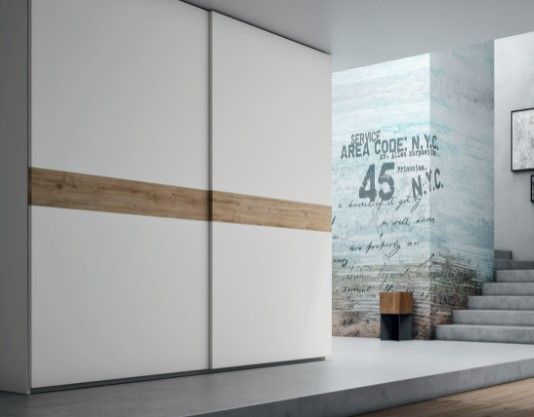 Un armadio bianco con ante scorrevoli e finiture in legno