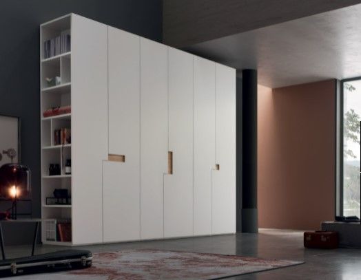 Una stanza con un grande armadio bianco e scaffali