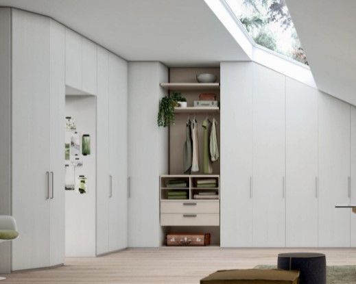 Una stanza con molti armadi e cassetti bianchi