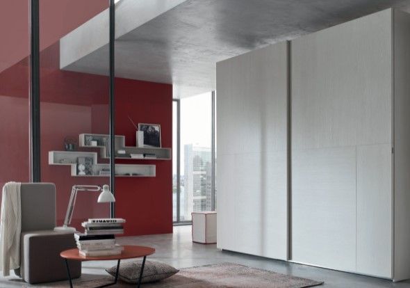 Un soggiorno con una parete rossa e mobili bianchi