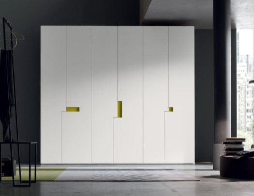 Un armadio bianco con maniglie gialle in una stanza