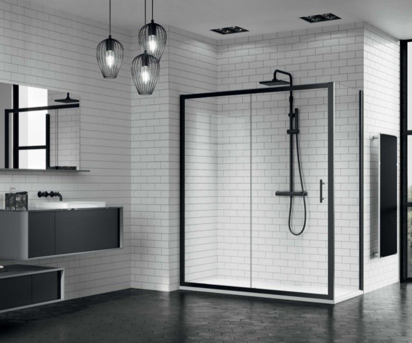 Un bagno con pareti in mattoni bianchi e cabina doccia nera.