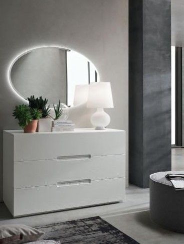 Un soggiorno con una cassettiera bianca e uno specchio rotondo.