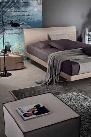 Una camera da letto con un letto, un comodino, un pouf e un tappeto.