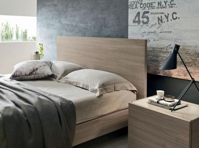 Una camera da letto con un letto e un comodino con un cartello sul muro che dice 45 nyc