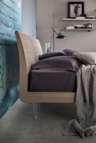 Una camera da letto con un letto, una lampada e un quadro sul muro.