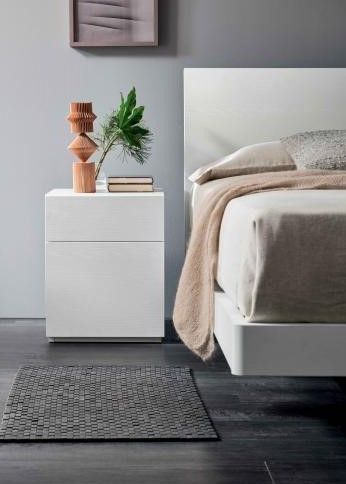 Una camera da letto con un letto, un comodino e un tappeto.