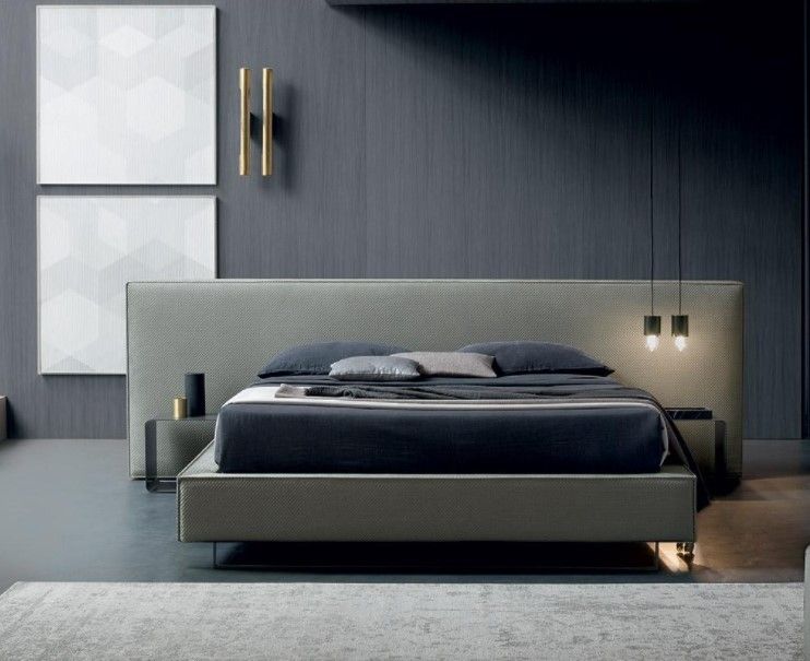 Una camera da letto con un letto, comodini e una parete grigia.