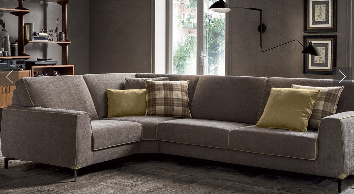 Un soggiorno con un grande divano componibile e cuscini