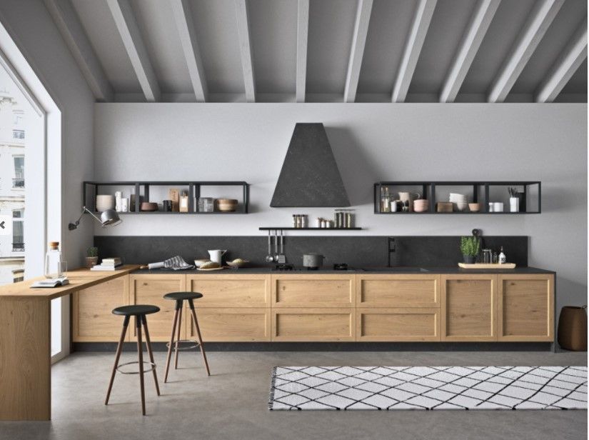 Una cucina con mobili in legno e una cappa nera