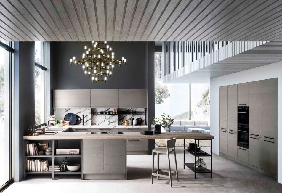 Una cucina con una grande isola al centro e un lampadario appeso al soffitto.