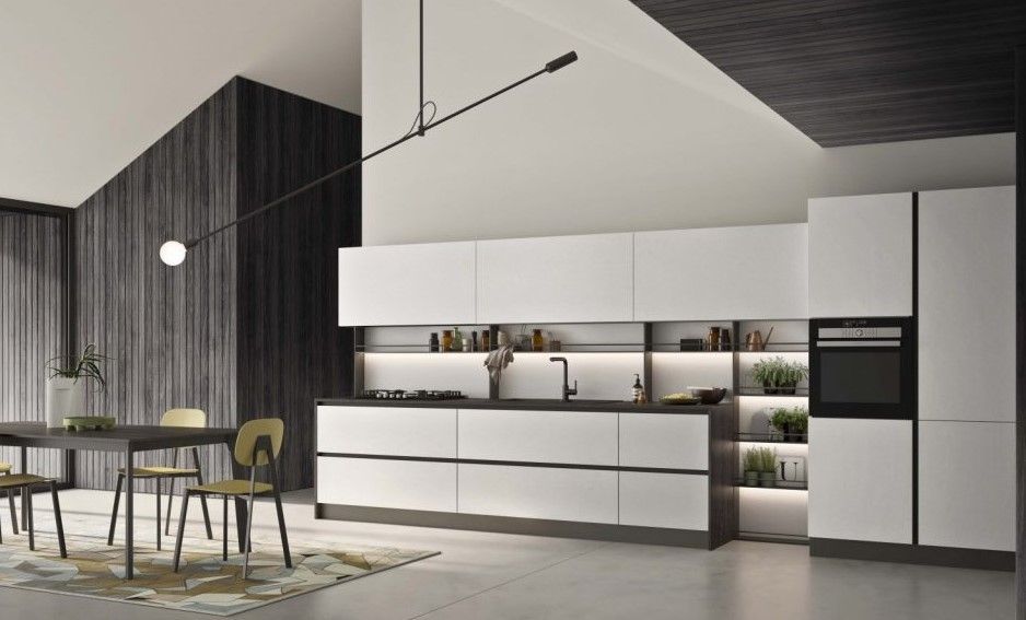 Una cucina moderna con mobili bianchi, tavolo da pranzo e sedie.