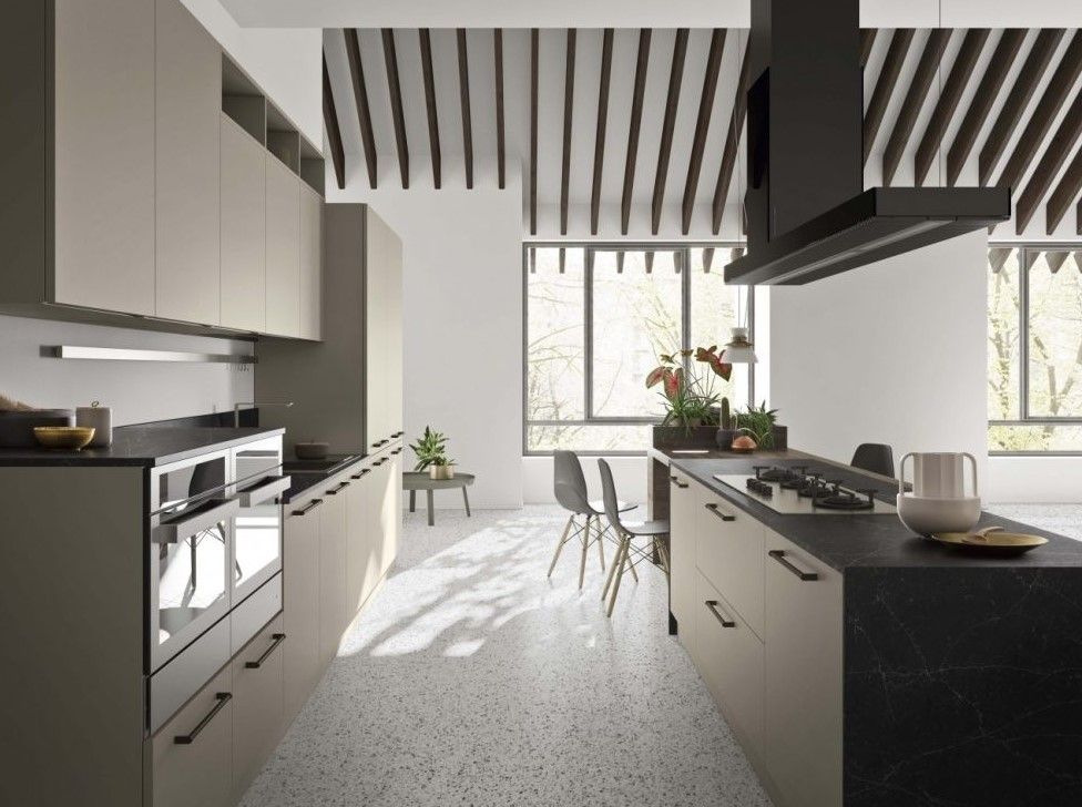 Una cucina con una grande isola al centro e un forno sul piano cottura.