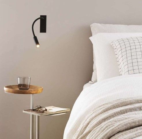 Una camera da letto con un letto e un tavolo con un bicchiere sopra