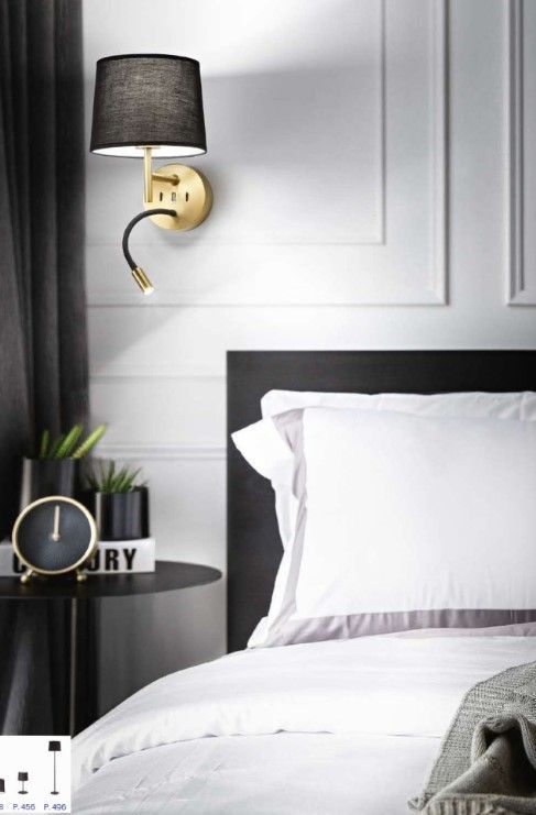 Una camera da letto con un letto, un comodino, un orologio e una lampada