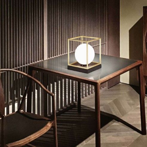 Un tavolo con una lampada sopra e una sedia