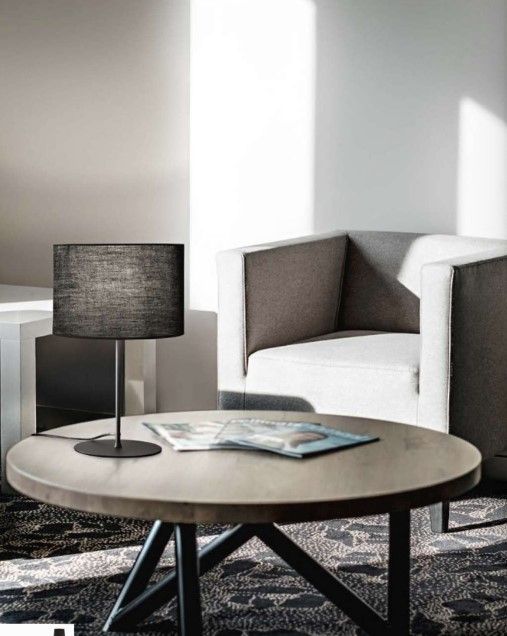 Un tavolo rotondo con una lampada sopra in un soggiorno