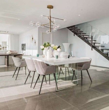 Una sala da pranzo con tavolo, sedie e una scala.