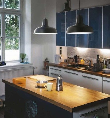 Una cucina con mobili blu e una grande isola di legno