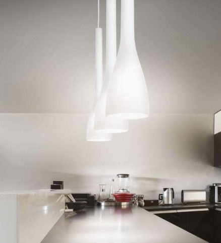 Una cucina con lampade a sospensione bianche appese al soffitto