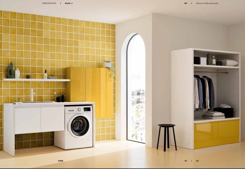 Una lavanderia con piastrelle gialle, lavatrice e asciugatrice