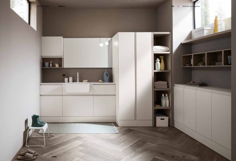 Una lavanderia con mobili bianchi e un lavandino