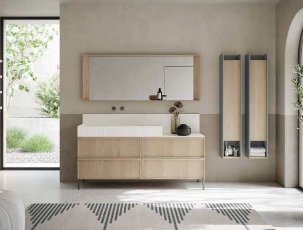 Un bagno con lavandino, specchio e armadietti.