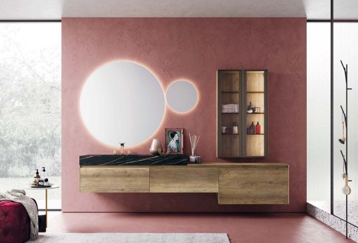 Un bagno con una parete rosa e un grande specchio