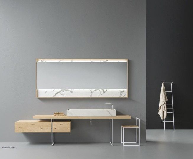 Un bagno con un lavandino, uno specchio e una sedia