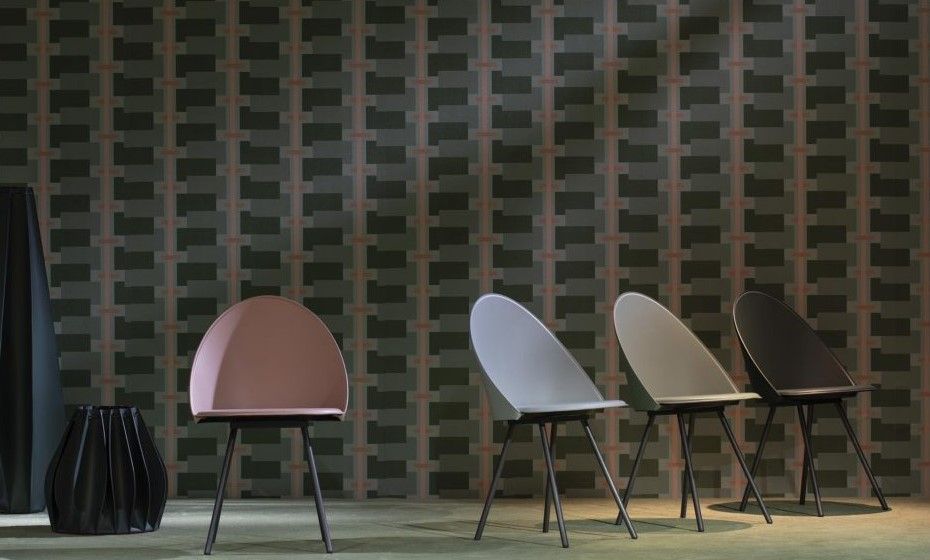 Una fila di sedie di fronte a un muro di mattoni.