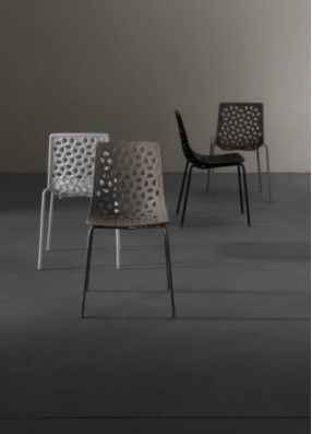 Tre sedie sono appoggiate una accanto all'altra su un pavimento grigio.