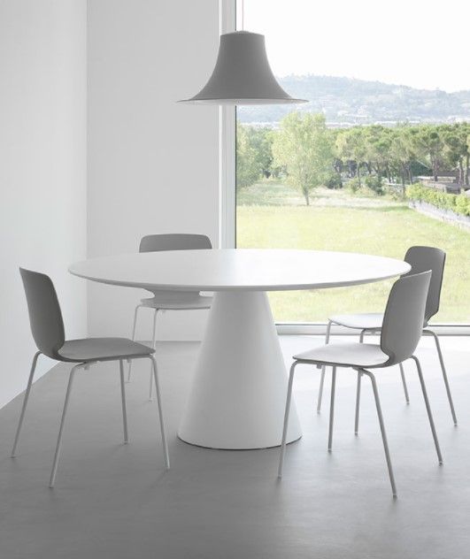 Una sala da pranzo con un tavolo e sedie davanti a una finestra