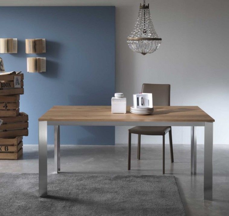 Una sala da pranzo con tavolo, sedie e un lampadario appeso al soffitto